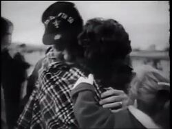 B/W 1960s woman holding small girl hugging soldier outdoors / Vietnam War homecoming / California Stock Footage