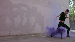 Cool young woman with purple mohawk dancing with purple powder cannon in urban parking lot Stock Footage