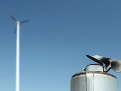 Smokestack and Wind Turbine against a Blue Sky Stock Footage