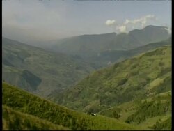 WA green hillside, pan left to grey smoke and ash cloud rising quickly upwards from crater, Mount Tunguragua, Ecuador Stock Footage