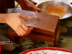 CU SLO MO Shot of cassava balls being flattened into crackers in wooden press / Luang Prabang, Laos Stock Footage