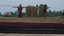 Fisherman return to the banks of the River Jamuna at sunset to unload sell auction and share their catch of small fish before tending to nets and returning home Stock Footage
