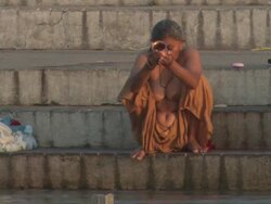 WS Woman sitting with eyes closed and praying on stone embankment at the Ganges river / Kashi, Uttar Pradesh, India Stock Footage