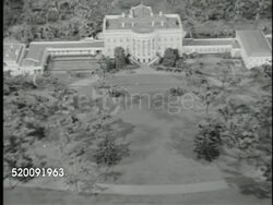 1948: WASHINGTON, D.C.: THE WHITE HOUSE: DRAMATIZATION: VS Unidentified man w/ folded blueprints standing at table w/ Lorenzo Winslow's miniature White House model, MS Male hand w/ pen pointing to South Portico Truman Balcony, VS Expansion buildings. Instructional Video