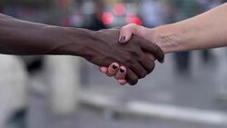 handshake between hand of black man and white woman - outdoor Stock Footage