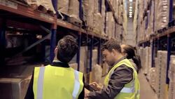Supervisor and workers taking inventory in distribution warehouse Stock Footage