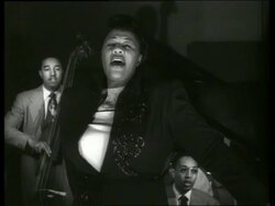 B/W close up Ella Fitzgerald singing with musicians in background Stock Footage
