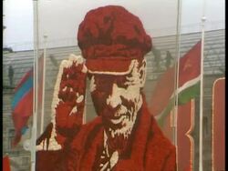 CU Tracking shot of large poster of Lenin, flags flying in background, during Soviet-era parade, Moscow Stock Footage