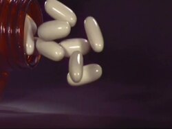SLOMO CU medicine bottle falling, white capsules spill out Stock Footage