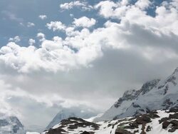 T/L of storm clouds passing over glacial mountain landscape Stock Footage