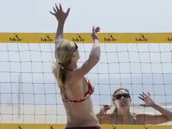 CU of female beach volleyball players spiking and blocking at the net. Stock Footage