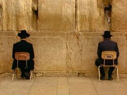 MS, two men praying sitting on chairs facing Wailing Wall, Jerusalem, Israel Stock Footage