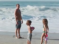 MS Boy and girl hold water balloons with man on beach then boy and girl run toward / Montezuma, Puntarenas, Costa Rica Stock Footage