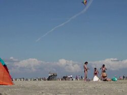 WS Shot of people drying himself after swimming out from beach and beach kite flying, North Sea North Frisia, / St. Peter Ording, Schleswig Holstein, Germany Stock Footage
