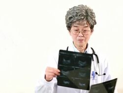 Female doctor examining an x-ray, smiling Stock Footage