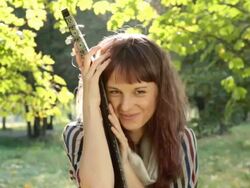 Young woman posing in park, holding guitar, smiling, flirting outdoors. Stock Footage