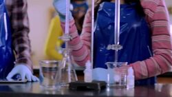 Students share tablets to conduct chemistry lab experiment Stock Footage