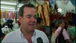 Revellers pick masks and garments to wear at carnival News Clip