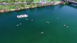 looking straight down at kayakers moving fast. Flying over the Middle of Lake Aerial View Austin Texas Colorado River Fun Spring water activities with kayakers and Party Boat during SXSW Spring Break 2016 Stock Footage