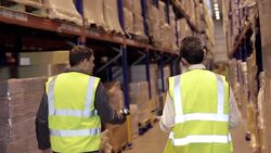 Worker scanning cardboard boxes in distribution warehouse Stock Footage
