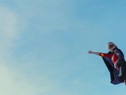 Low angle wide shot young blonde woman in mask, cape, and superhero costume in midair simulating flying after jumping on trampoline / Las Vegas, Nevada Stock Footage