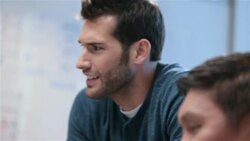 Older businessman types on smart-phone; trendy young businessman leads meeting in office conference-room Stock Footage