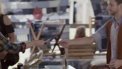 Young man in Texas flea market hands credit card to cashier who swipes on iPad Stock Footage