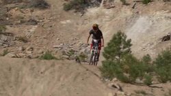 Teenage boy mountain biker doing tricks off dirt jumps. - Slow Motion Stock Footage