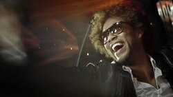 Hip-hop star points and waves at fans from back of limousine at awards show Stock Footage