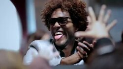 Hip-hop star smiles and sticks tongue out at fans crowded around red carpet at awards show Stock Footage