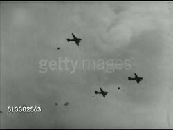 1942: FORT JACKSON REVIEW: TU WS Aircraft in silhouette w/ US Army infantry paratrooper parachutes opening in line behind aircraft, British Prime Minister Winston Churchill holding cupped hands around eyes.  Note: Poor contrast. Instructional Video