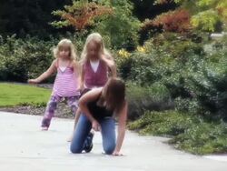 MS  One girl drawing hopscotch with chalk on sidewalk and two girls skip and play hopscotch  / Langley, British Columbia, Canada. Stock Footage