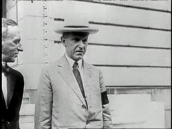 President Calvin Coolidge stands and talks with another man. News Clip