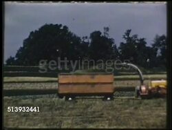 1950: AGRICULTURAL MACHINERY: COLOR:  VS Farmers driving tractors pulling harvester machine shooting harvest into trailer behind, other farmers driving tractors, harvesters across farmland, crops. Agriculture, country Instructional Video