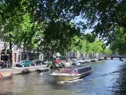 WS View of boats docked while tour boat moving by / Amsterdam, The Netherlands, Holland Stock Footage