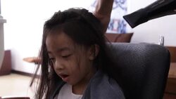 stylist blow drying her client's hair Stock Footage