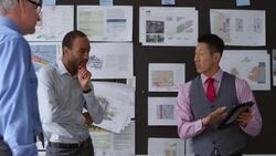 MS Businessman presenting project on digital tablet to coworkers in office Stock Footage