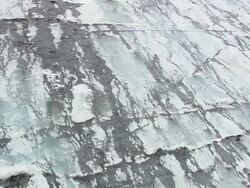 WS AERIAL ZO View of small stream with ice sheet melting patterns / Iceland Stock Footage