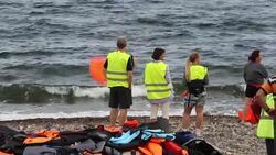Syrian migrants fleeing the war and escaping to Europe, landing on the Greek island of Lesvos on the north coast at Efthalou and helped ashore by volunteers. Up to 4,000 migrants a day are landing on the island and overwhelming the authorities. They are tr Stock Footage