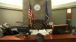The American flag and the flag of Nevada frame a desk in a courtroom. Stock Footage