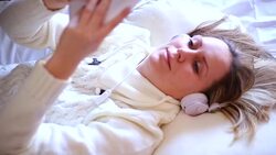 girl holding a tablet pc lying on a bed Stock Footage