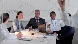 Scientist drawing chemistry diagram on glass for colleagues Stock Footage