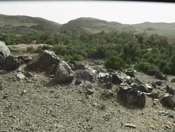 Large rocks stand in the stoney ground, over looking the green and mountainous landscape. Stock Footage