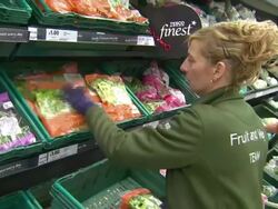 Tesco staff member refilling the salad display News Clip