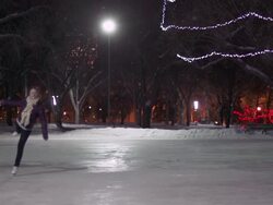 Caucasian female teenager skates with joy on a snowy night.. Stock Footage
