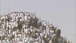 A massive crowd of Muslim men gather on a hilltop at Mecca. Stock Footage
