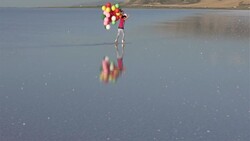 Middle Eastern little girls walking on the water with color balloons - SLOW MOTION Stock Footage