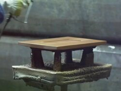 gloved hands of worker spray painting piece of furniture in spray-painting chamber Stock Footage