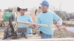 Young couple volunteers working together on home built for charity Stock Footage