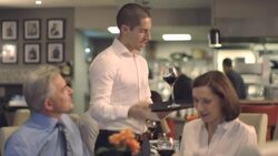 MS TU  Man and woman in restaurant, waiter serving wine Stock Footage